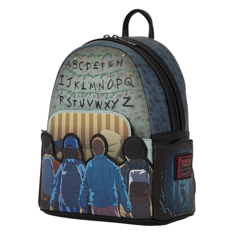 A small backpack featuring a Stranger Things graphic print with the alphabet letters and string lights on the front, illustrated characters on the lower pocket area, and a black side pocket with a red brand patch.