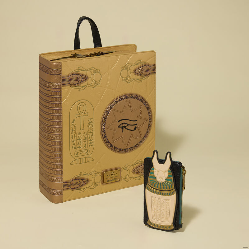 Decorative book with Egyptian hieroglyphics and a small bottle on a beige background