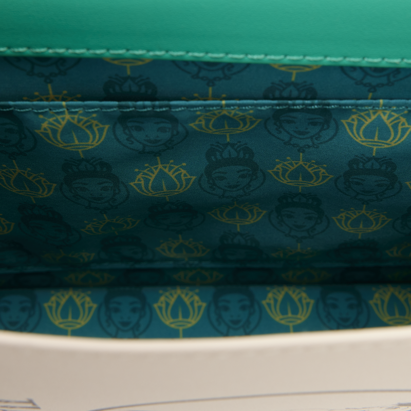 Close-up of a green fabric with a pattern of faces and symbols.