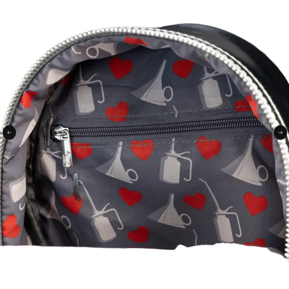 Backpack with a pattern of red hearts and gray megaphones on a dark background.