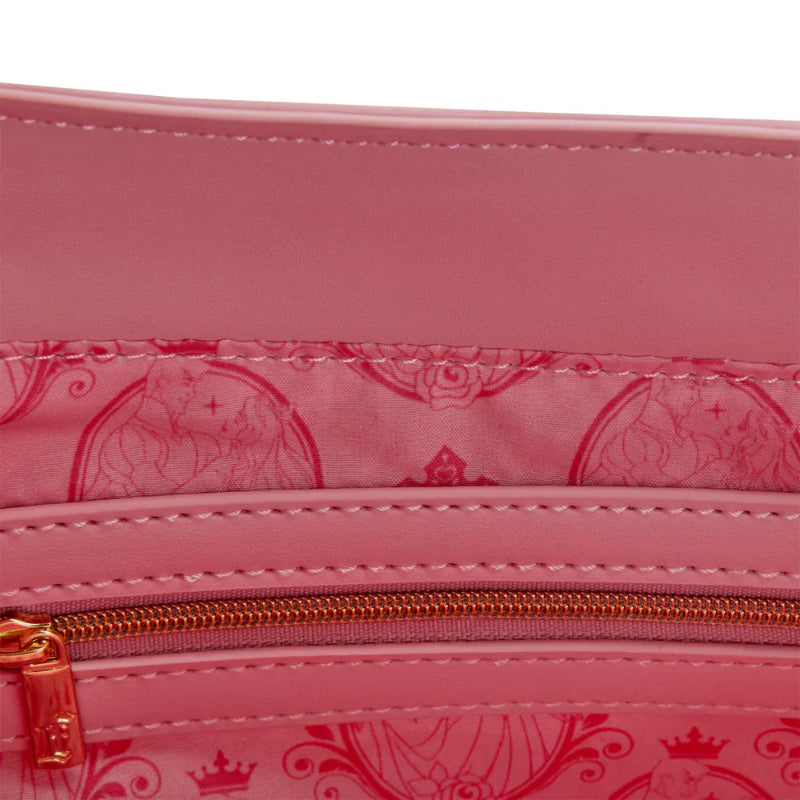 Close-up of a pink bag with a gold zipper and decorative pattern.