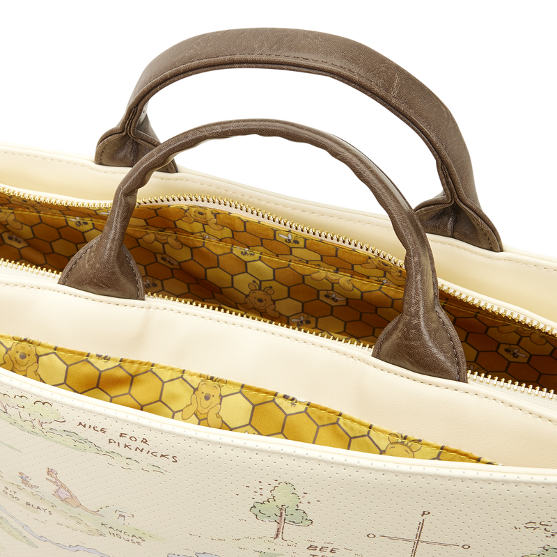 Close-up of a beige bag with brown handles and a detailed interior pattern.