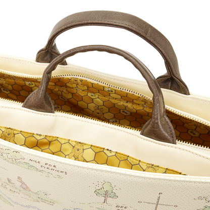 Close-up of a beige bag with brown handles and a detailed interior pattern.