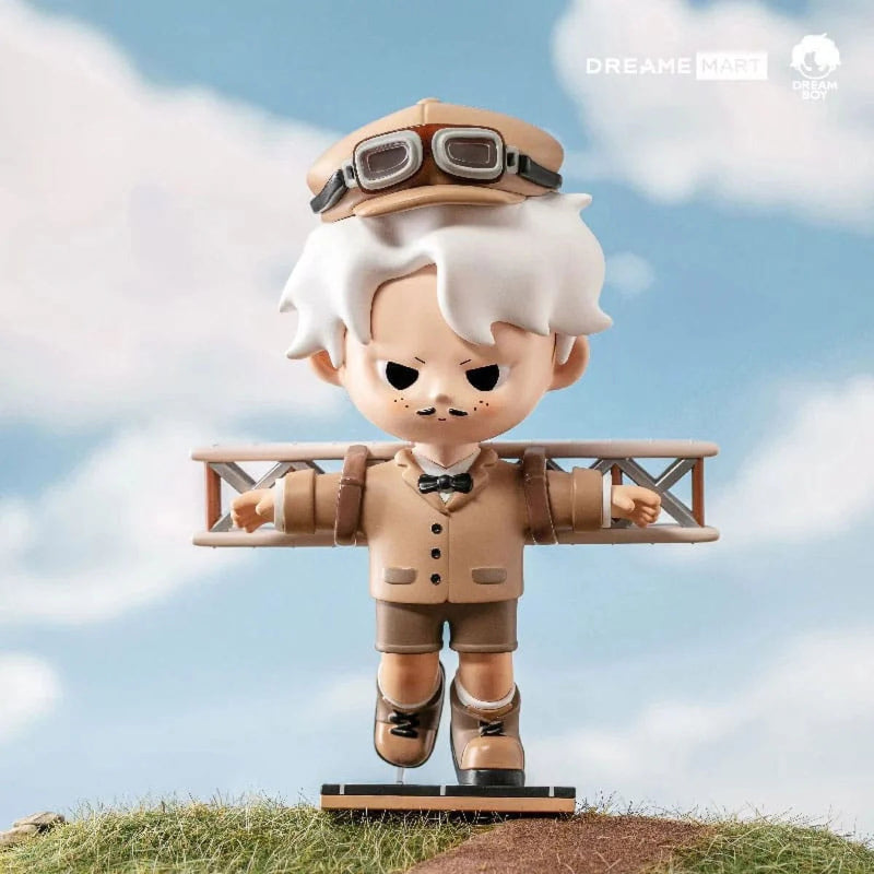 Toy figure of a character in an aviator outfit with airplane wings against a blue sky background.