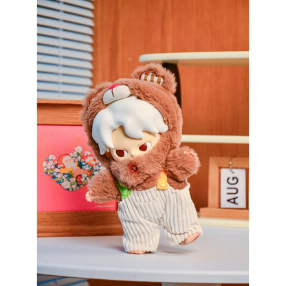 Plush toy with a lion costume on a white surface with a wooden background