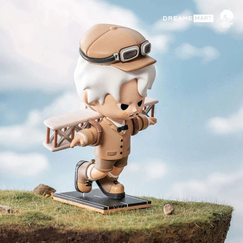 Statue of a character in pilot attire with a small airplane on a grassy platform against a cloudy sky.