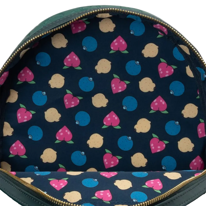 Close-up of the interior of a green backpack showing a navy blue fabric lining with a colorful pattern of pink strawberries, blue blueberries, and beige lemons, finished with gold-tone zippers.