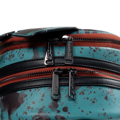 Close-up of a bag with multiple zippers and a splatter pattern.