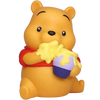 A Winnie the Pooh bear figurine or bath toy in a sitting pose, holding a honey pot with yellow honey dripping over it. The bear is yellow with a red shirt, and the pot is purple and blue, set against a plain white background.