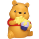 A Winnie the Pooh bear figurine or bath toy in a sitting pose, holding a honey pot with yellow honey dripping over it. The bear is yellow with a red shirt, and the pot is purple and blue, set against a plain white background.