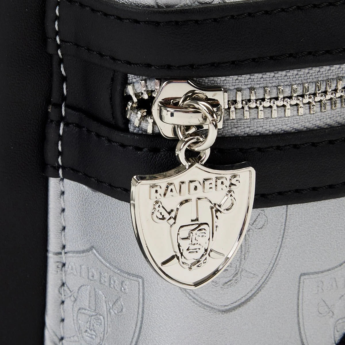 Close-up of a Raiders emblem on a black and gray bag.