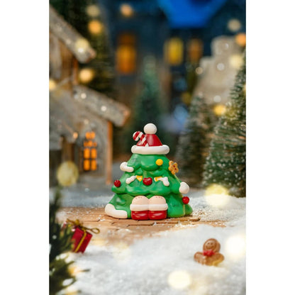 Decorative Christmas tree figurine with a Santa hat in a festive setting with lights and trees.