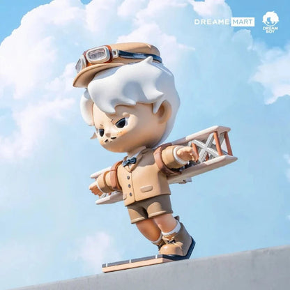 Toy figure of a character in an aviator outfit with a clear blue sky background