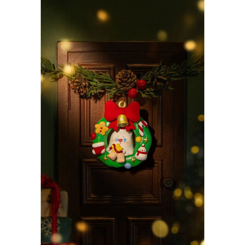 Decorative Christmas wreath with a bell and reindeer on a wooden door.