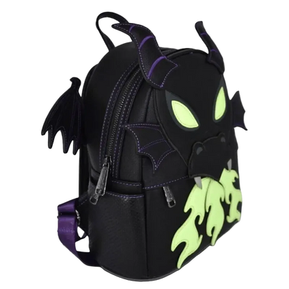 A black faux-leather backpack designed like a dragon head, featuring purple stitching, glowing neon green eyes, a neon green flame-like mouth, and small black wings on the sides, shown on a plain white background.