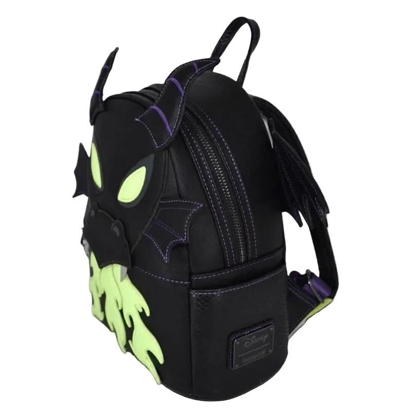 A black faux-leather Disney Nightmare Before Christmas mini backpack shaped like Malice, featuring neon green glowing eyes and mouth details, purple stitching, and bat-wing accents, shown on a plain white background.