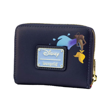 A navy blue zip-around wallet featuring a metallic silver Disney Loungefly plaque on the front, decorated with a blue and purple splash graphic and a yellow genie lamp keychain illustration. The wallet is shown on a white surface with a black background.