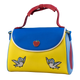 Colorful handbag with blue top section, yellow bottom section, red handle, and bird and apple designs on a blue background.