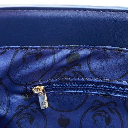 Close-up of a blue bag with a gold zipper, featuring Disney princesses and apple designs.