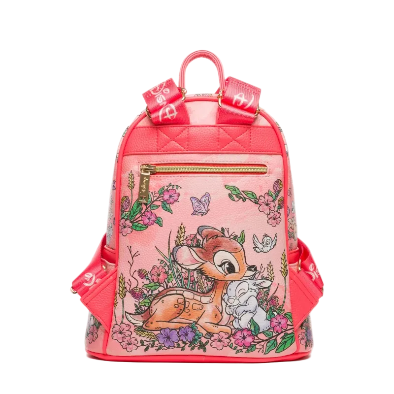 A pink faux-leather backpack featuring a Bambi illustration with flowers, butterflies, and a deer, accented with red straps and gold zippers.
