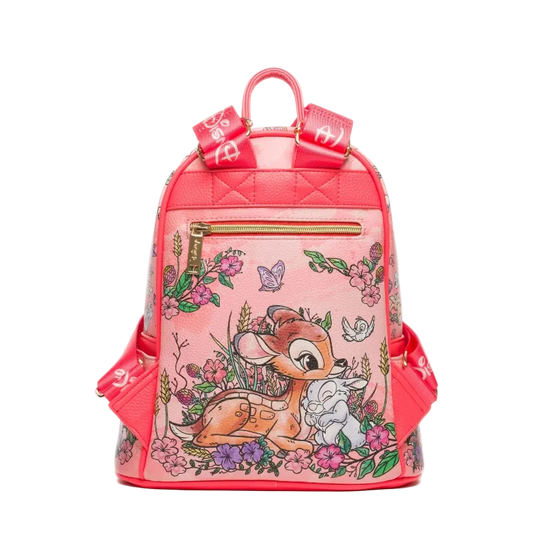 A pink faux-leather backpack featuring a Bambi illustration with flowers, butterflies, and a deer, accented with red straps and gold zippers.