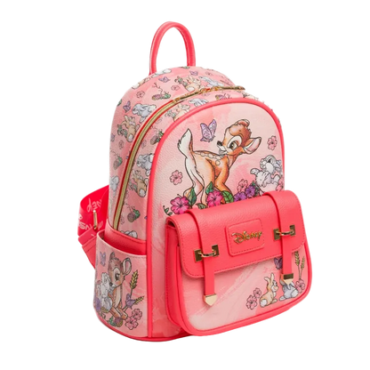 A pink Disney-themed backpack featuring Bambi, Totoro, and other Disney characters on a white background. The backpack has a pink faux-leather body with a bright pink front pocket, gold-tone hardware, and a top handle.