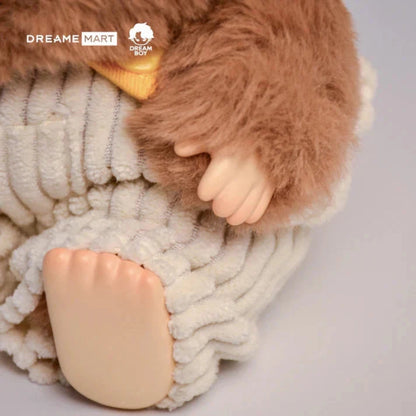 Plush toy lion wearing a knitted sweater on a light gray background with 'Dreame Mart' branding.