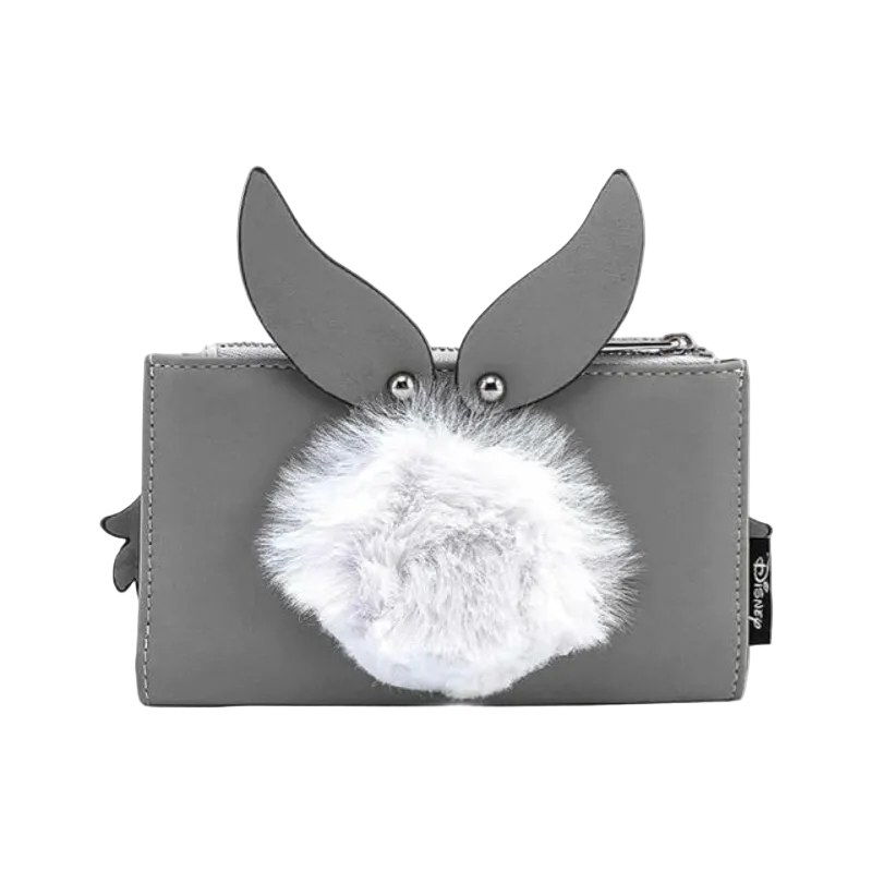 A gray zip-around wallet featuring a rabbit face design with upright ears, silver metal eye studs, and a fluffy white faux-fur pom-pom in front. A small black fabric tag with white text is visible on the right side.